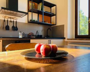 drei Äpfel auf einem Teller auf einem Tisch in einer Küche in der Unterkunft La finestra sul parco Croara Country Club in Pieve Dugliara