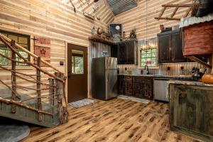 kuchnia z lodówką i drewnianymi ścianami w obiekcie Magical Treehouse with Slide by Brazos River for Family Glamping Adventures in Texas w mieście Buckner