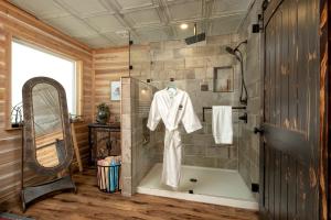 Łazienka z prysznicem i szlafrokiem wiszącym na ścianie w obiekcie Magical Treehouse with Slide by Brazos River for Family Glamping Adventures in Texas w mieście Buckner