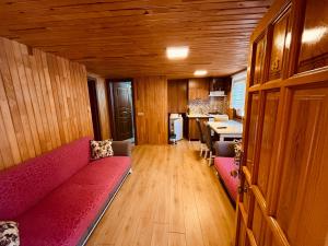 a living room with a red couch and a kitchen at Desera Pansiyon in Uzungöl