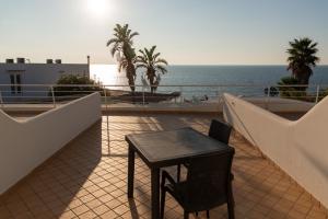 a table and chair on a balcony with the ocean at Hotel Albatros in Ischia
