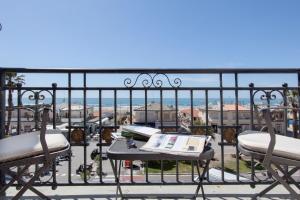 a balcony with two chairs and a table with a book at Palace Hotel in Viareggio