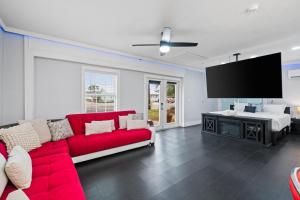 un soggiorno con divano rosso e TV a schermo piatto di Splash Pad by Book That Condo a Panama City Beach