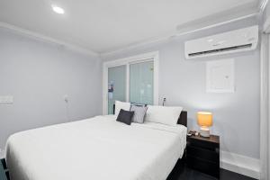 una camera da letto bianca con un letto grande e una finestra di Splash Pad by Book That Condo a Panama City Beach Altre 79 foto