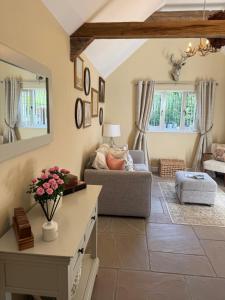 a living room with a couch and a table at Mulberry House Farm Mulberry Lodge in Chippenham