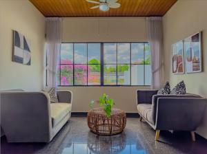 a living room with two couches and a large window at Cardedeu Suites in San Salvador