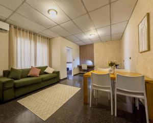 a living room with a green couch and a table and chairs at Cardedeu Suites in San Salvador
