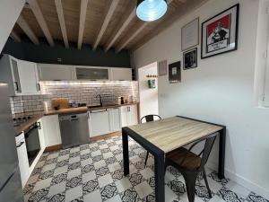 a kitchen with a wooden table and a table and chairs at Belle maison chaleureuse dans le centre de Brindas in Brindas +3 photos