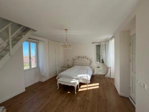 a white bedroom with a bed and a window at Petite maison à côté d'Argenton-sur-Creuse in Vigoux