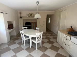 a kitchen with a table and chairs in a room at Petite maison à côté d'Argenton-sur-Creuse in Vigoux