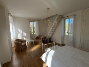 a bedroom with a white bed and a staircase at Petite maison à côté d'Argenton-sur-Creuse in Vigoux