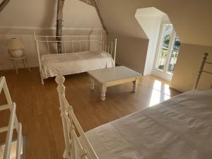 a bedroom with two beds and a table in it at Petite maison à côté d'Argenton-sur-Creuse in Vigoux