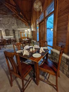 KhapaluDestination Hotel Khaplu的配有木桌椅的餐厅