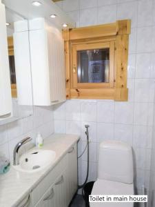a bathroom with a toilet in a main house at Spacious villa with great scenery and nature in Pertunmaa