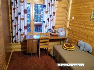 a bedroom with a desk and a bed and a window at Spacious villa with great scenery and nature in Pertunmaa +16 photos