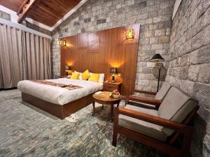 KhapaluDestination Hotel Khaplu的一间卧室配有一张特大号床和一把椅子