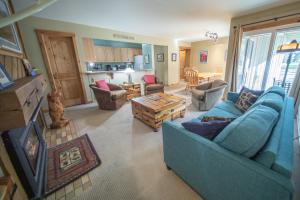 a living room with a blue couch and a table at Flying Dutchman 1192 by SummitCove Lodging in Keystone