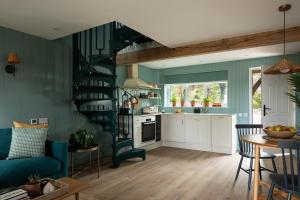 a kitchen and living room with a spiral staircase at Owl's Perch - Otium Wine Estate in Alton