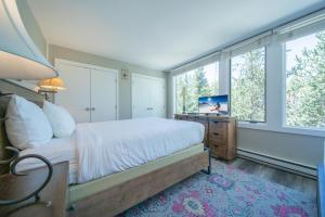 ein Schlafzimmer mit einem Bett und einem Fernseher und Fenstern in der Unterkunft Argentine 1511 by SummitCove Lodging in Keystone + 48 Fotos
