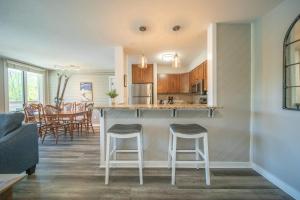 eine Küche und ein Wohnzimmer mit einer Theke und Stühlen in der Unterkunft Argentine 1511 by SummitCove Lodging in Keystone