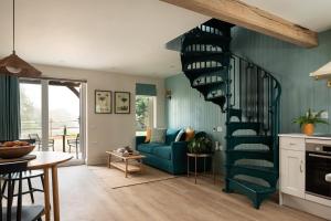 a spiral staircase in a living room with a blue couch at Owl's Perch - Otium Wine Estate in Alton