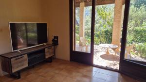 a living room with a flat screen tv and a patio at Villa GiGa Algajola in Algajola