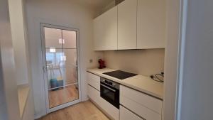 a kitchen with white cabinets and a stove top oven at Apartamento moderno en un Resort de 4 Estrellas in Islantilla