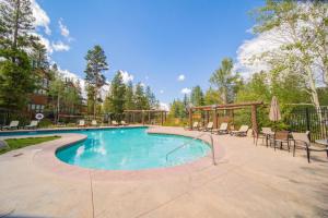 a swimming pool with chairs and a gazebo at Soda Spring 1910 by SummitCove Lodging in Keystone