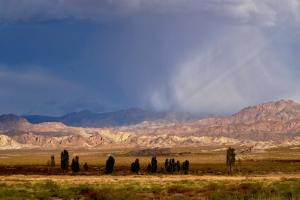 a group of people standing in a field with mountains at Casa Munay in Uspallata