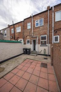 Un estacionamiento vacío frente a un edificio de ladrillos en Cosy 2BR Home in Darlington Near Hospital, en Darlington