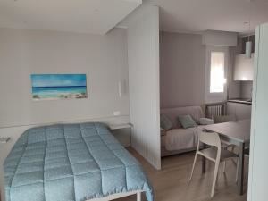 una camera da letto con un letto, un tavolo e un divano di Due passi dal mare a Bellaria-Igea Marina
