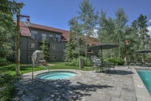 eine Terrasse mit Pool, Tisch und Sonnenschirm in der Unterkunft Expedition Station 8593 by SummitCove Lodging in Keystone