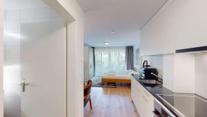 a kitchen with white cabinets and a table in a room at Cute and central studio - Sun 11 in Zurich +5 photos