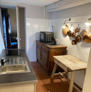 a kitchen with a sink and a microwave at Campagne Baudeloup in L'Isle-sur-la-Sorgue