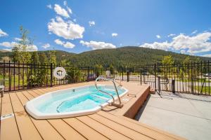 a jacuzzi tub on a deck with a mountain at Clearwater Lofts Bldg 3 103 by SummitCove Lodging in Keystone