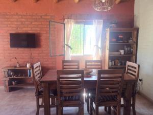 a dining room with a wooden table and chairs at Casa Munay in Uspallata