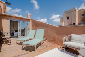 a patio with two chairs and chairs on a wooden deck at Gran Claustre Boutique Hotel in Altafulla
