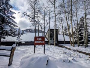a sign in the snow in front of a house at Pines 2161 by SummitCove Lodging in Keystone