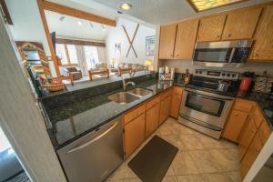 una cocina con fregadero y estufa horno superior en Quicksilver 1618 by SummitCove Lodging, en Keystone