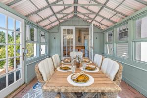 a dining room with a table and chairs at The White Pillars in South Dennis