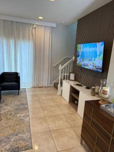 Una sala de estar con un televisor de pantalla plana en una pared. en 2BR Townhouse Near Disney, en Kissimmee