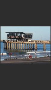 un molo con persone sulla spiaggia vicino all'acqua di Serenity 905 a Durban