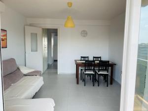 a living room with a table and chairs and a couch at Apartamento playa in Blanes