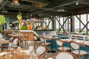 a restaurant with tables and chairs and a bar at Corendon Amsterdam Schiphol Airport, a Tribute Portfolio Hotel in Badhoevedorp +53 photos