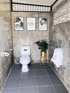 a bathroom with a toilet and a urinal and a sink at Baan Bua Homestay & Poolvilla in Ban Pa Mak (1)