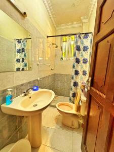 a bathroom with a sink and a toilet at Shanzu Oceanline Apartments La Mera in Mombasa