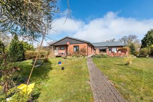 ein Haus mit einem gemauerten Weg vor einem Hof in der Unterkunft Grenznah Garten Ruhig in Ladelund