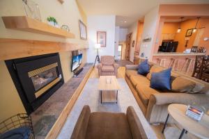un soggiorno con divano e camino di Quicksilver 1641 by SummitCove Lodging a Keystone
