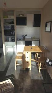 サン・ラリー・スランにあるAppartement Pied des pistes Vue sur les sommetsの小さなキッチン(木製のテーブルと椅子付)