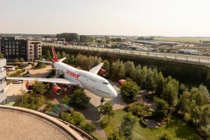 un avion est garé sur un parking à côté d'une autoroute dans l'établissement Corendon Amsterdam Schiphol Airport, a Tribute Portfolio Hotel, à Badhoevedorp 50 autres photos